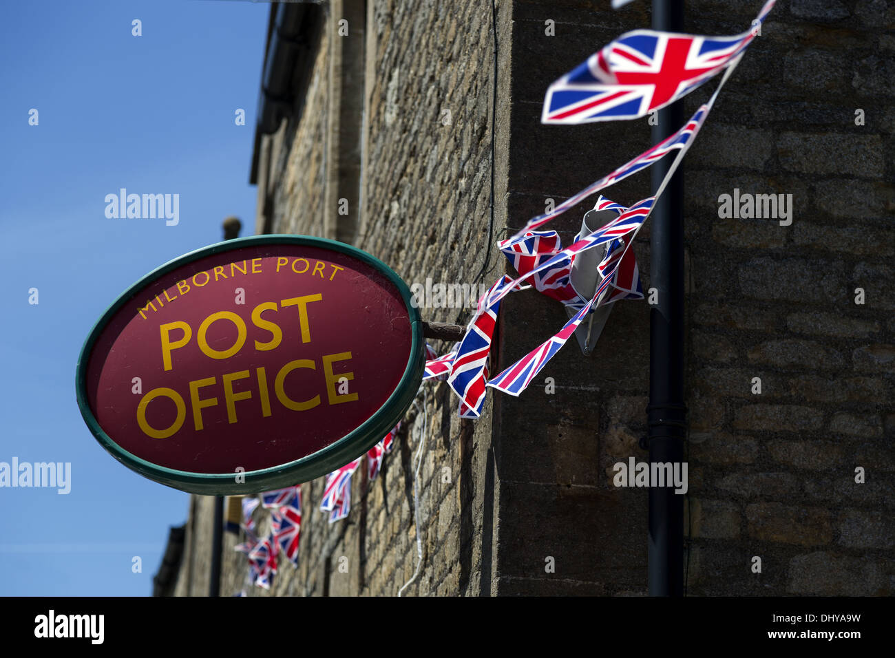 Britische Post Zeichen und Union flag Bunting gegen Himmel und Backstein-Gebäude Stockfoto