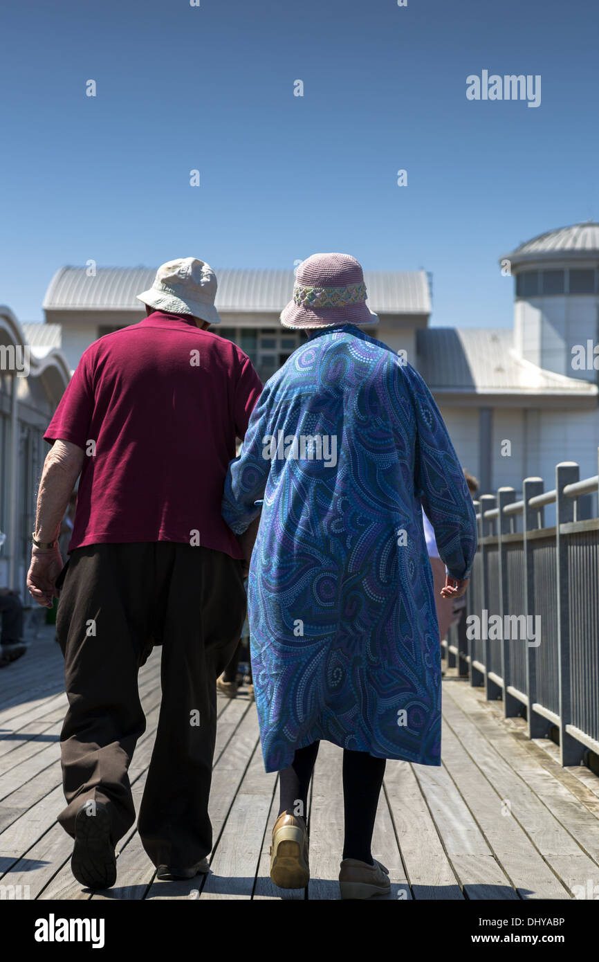 Älteres paar hand in hand gehen von hinten betrachtet Stockfoto