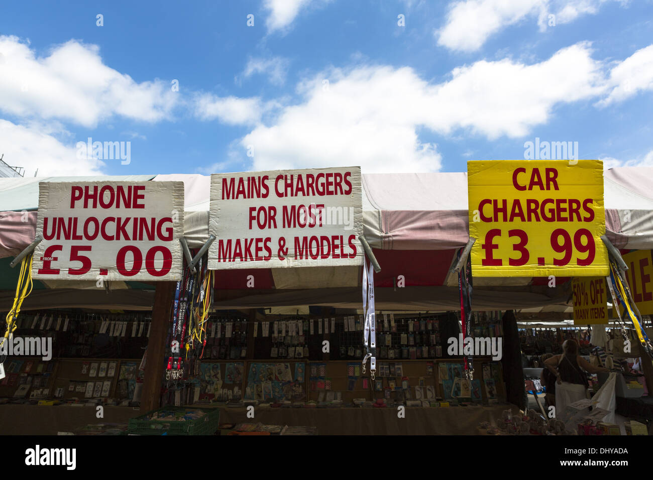Handy entsperren Zeichen und Kfz-Ladegeräte melden Sie auf einem Marktstand in England Stockfoto
