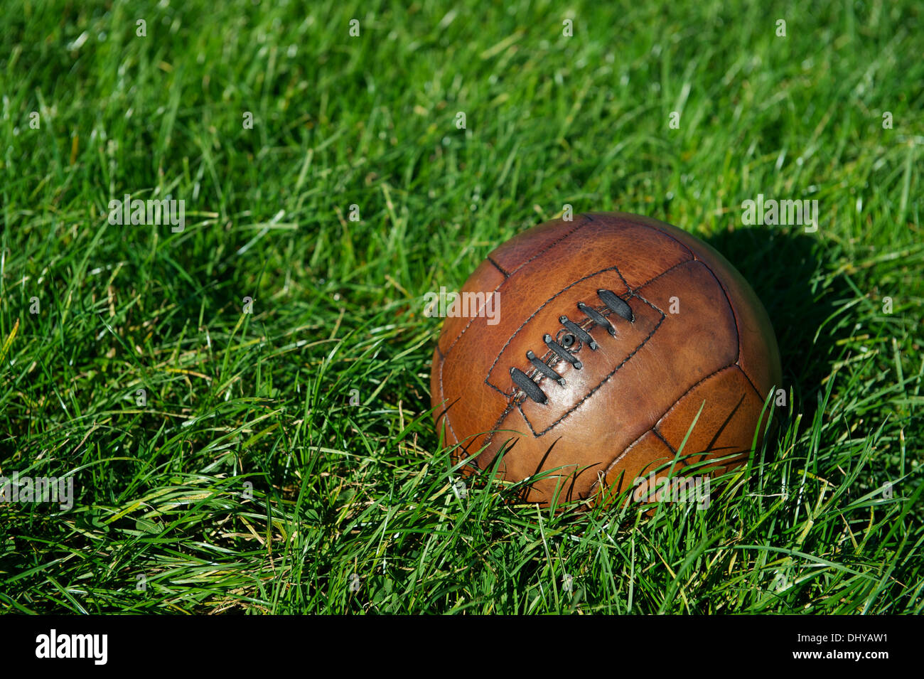 Vintage braun Fußball Fußball sitzt im sonnigen grünen Wiese Stockfoto
