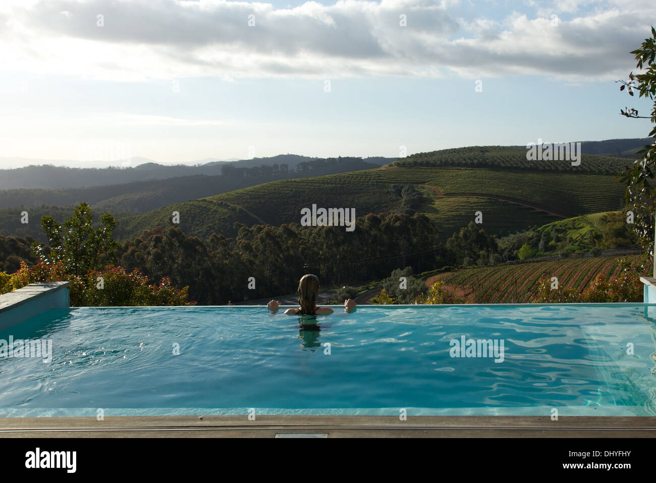 Eine Frau genießt die Aussicht über den Winelands Stellenbosch einen Infinity-Pool in Südafrika. Stockfoto
