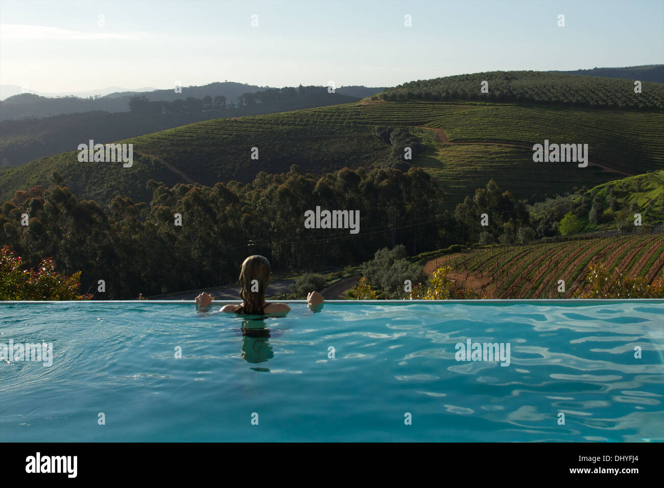 Eine Frau genießt die Aussicht über den Winelands Stellenbosch einen Infinity-Pool in Südafrika. Stockfoto