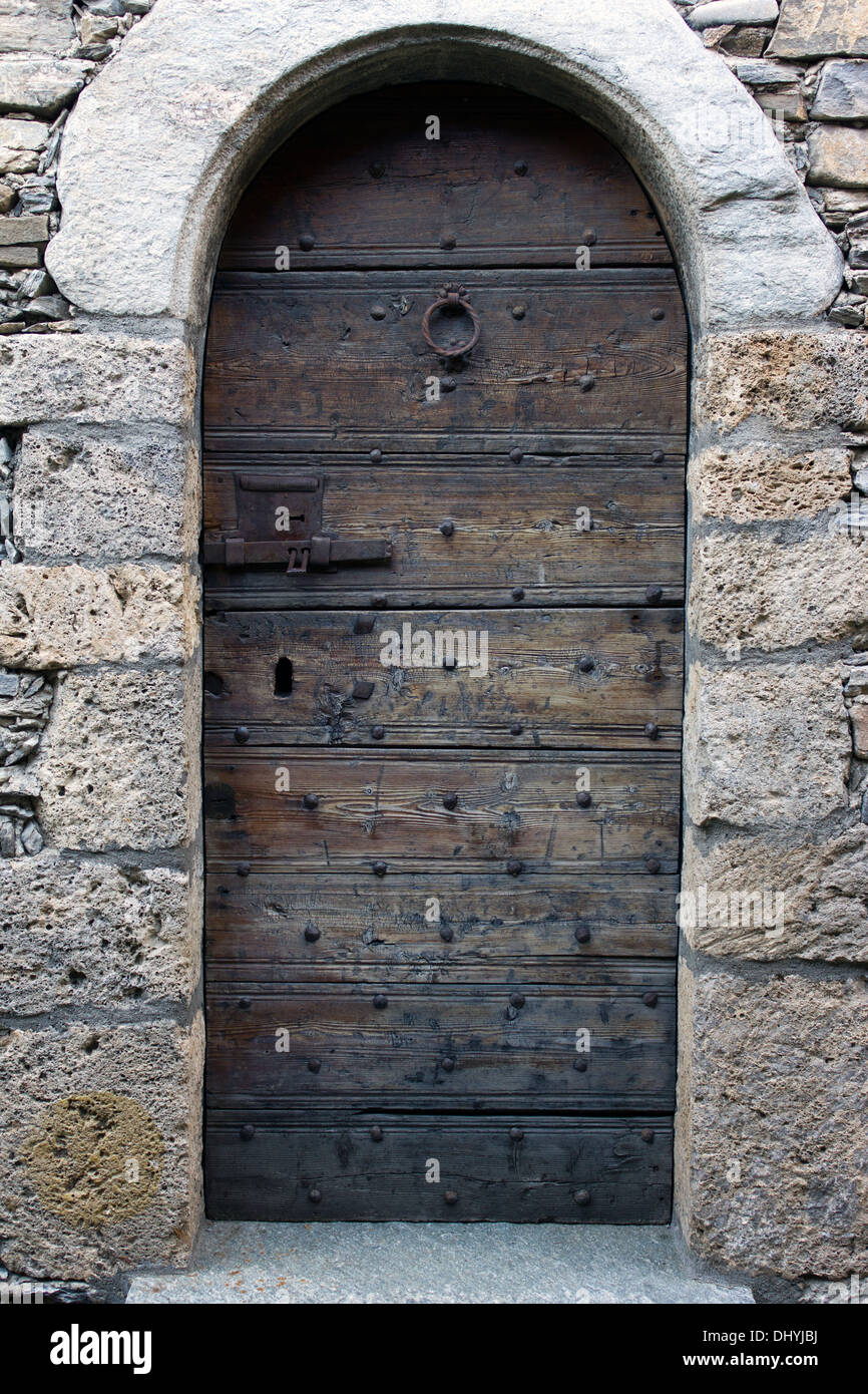 Alte Holztür mit steinernen Rahmen Stockfoto