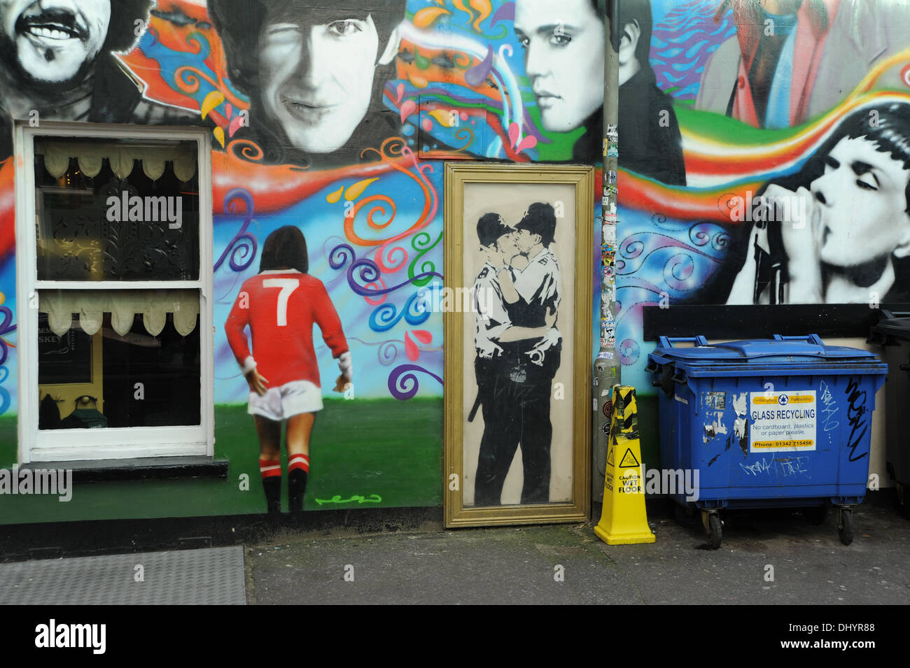 Eine Leinwandkopie der Banksy-Graffiti-Kunst der beiden Kissing-Polizisten (Kissing Coppers) im Prince Albert Pub in Brighton, Großbritannien, plus George Best Stockfoto