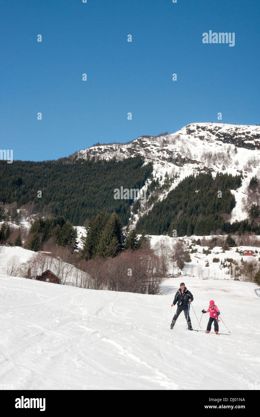 Junges Mädchen lernen Skifahren auf Bunny Hill mit ihrem Vater im Sognski Center, Holzbauweise, Norwegen Stockfoto