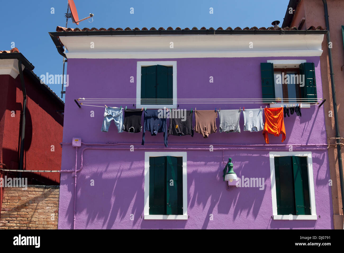 Burano - lila Haus mit Trocknen von Kleidung Stockfoto