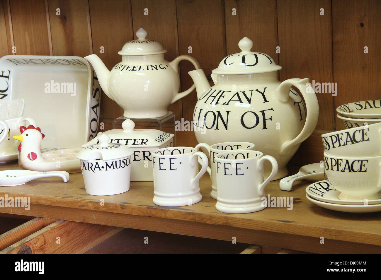 Teekannen und Tassen auf einem hölzernen Regal in der Küche Stockfoto
