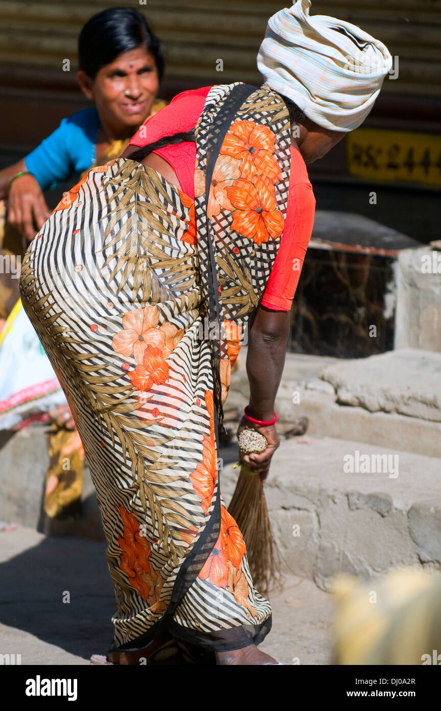 Indische Frau Straßenkehrer in Puttaparthi in Süd-Indien, ein Wallfahrtsort für viele spirituell Suchende am Werk. Stockfoto