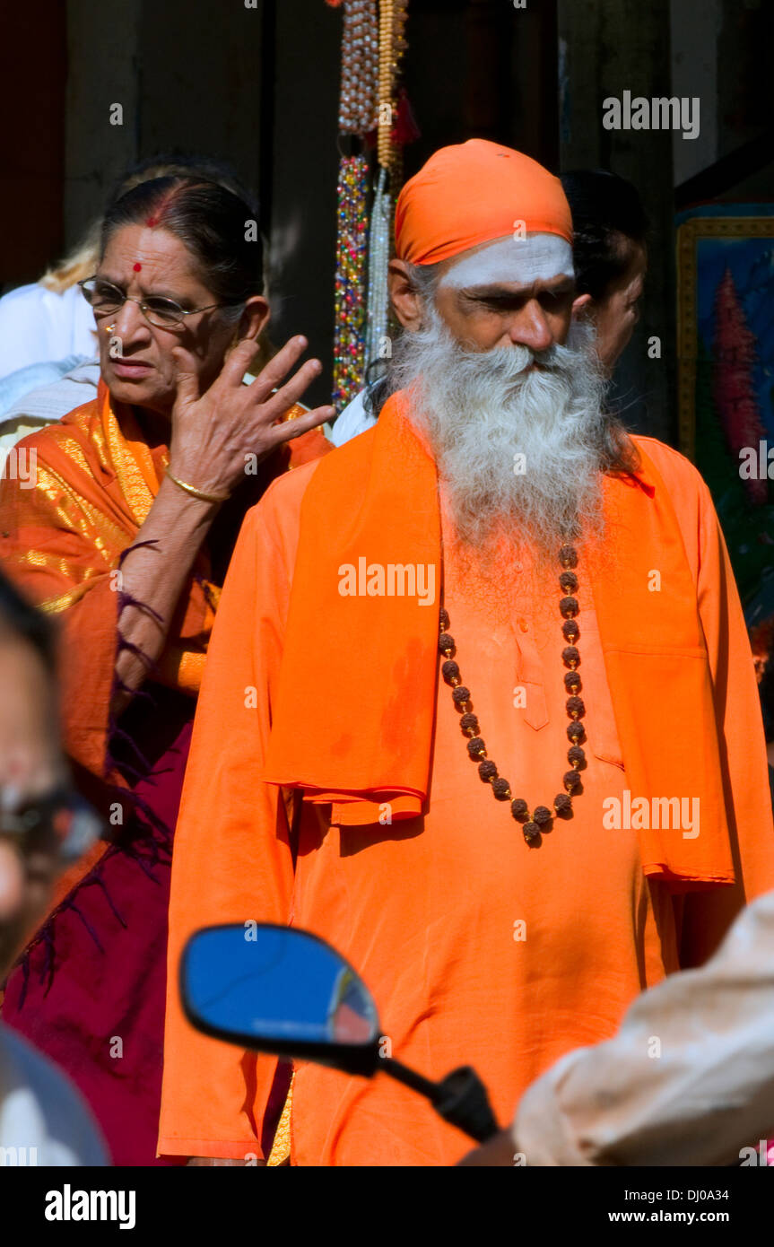 Indischen Sadhu gekleidet in traditionellen Orange mit fließenden Bart, Kopftuch und Rudraksha Perlen um den Hals. Straßenszene. Stockfoto