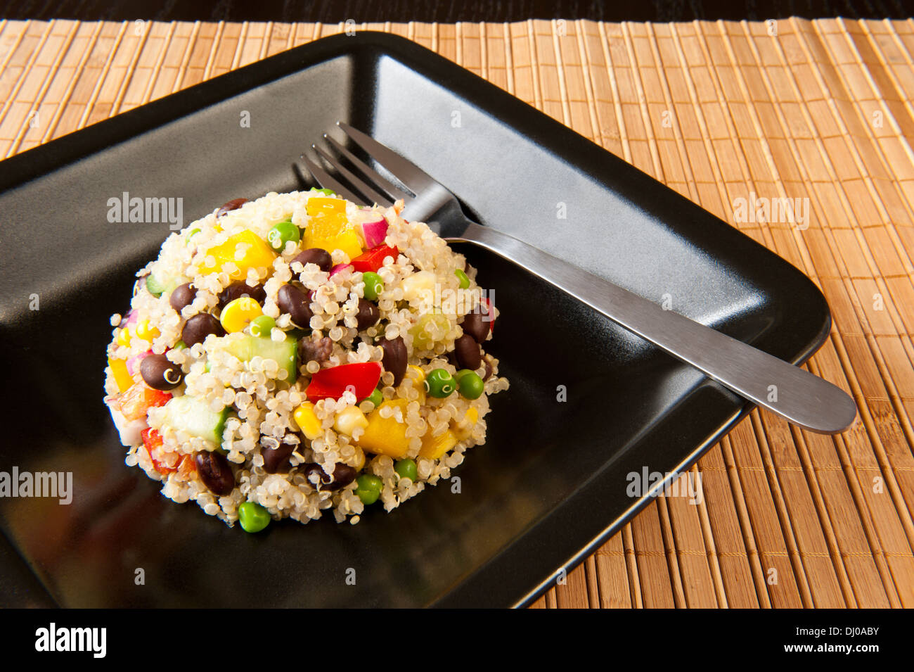 Quinoa Salat mit buntem Gemüse auf einer schwarzen Platte Stockfoto