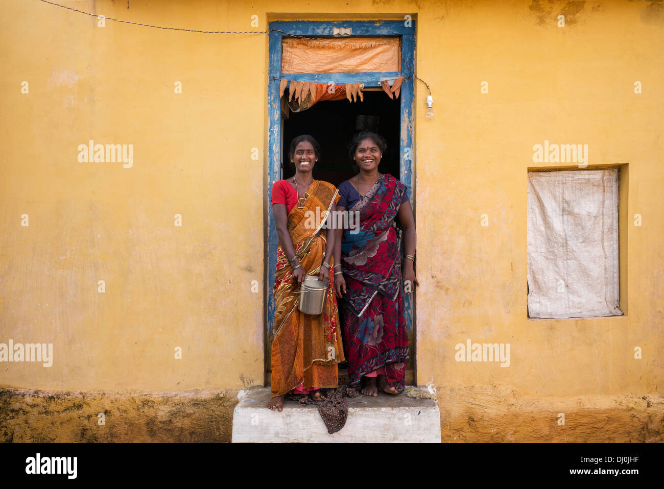 Zwei indische Dorf Frau in ihrem Haus Tür lachen. Andhra Pradesh, Indien Stockfoto