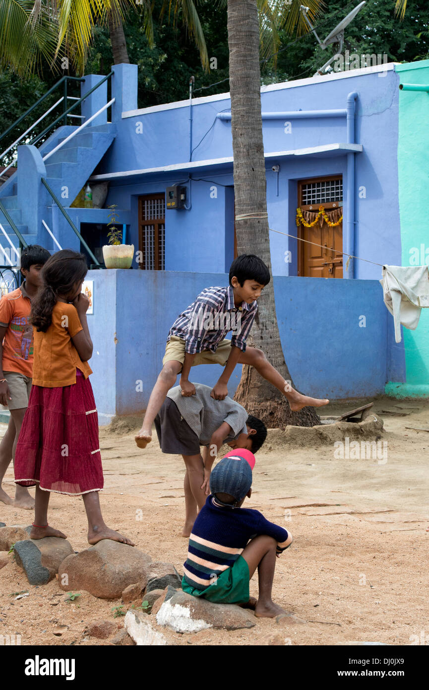 Indianerdorf jungen Spiel einen Sprung Frosch in einem indischen Dorf. Andhra Pradesh, Indien Stockfoto