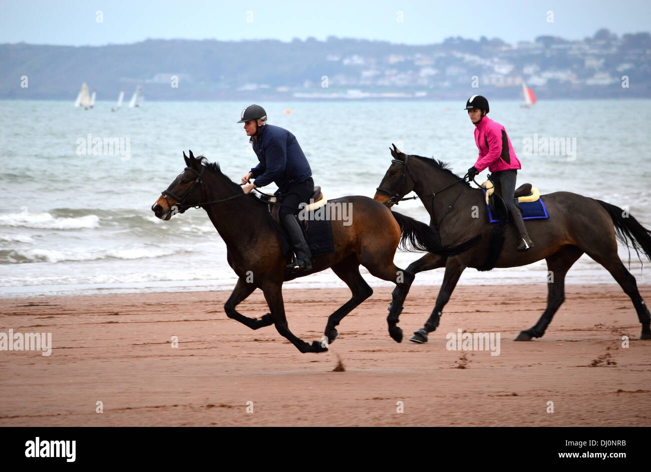 Zwei Reiter auf Paignton Beach, Torbay, Devon, England, Vereinigtes Königreich Stockfoto