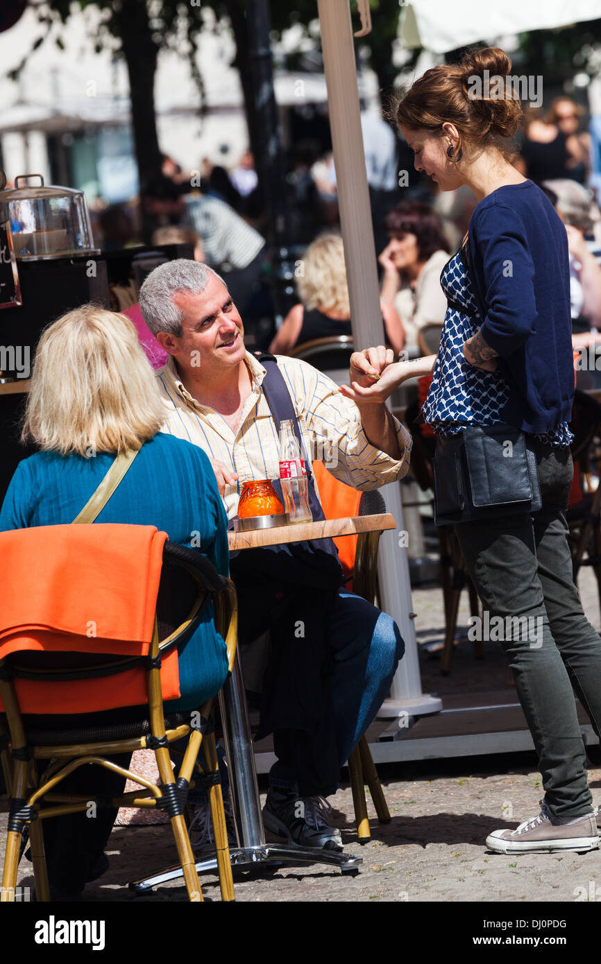 einer Kellnerin ein Trinkgeld zu geben. Straßencafé Kopenhagen Dänemark Stockfoto