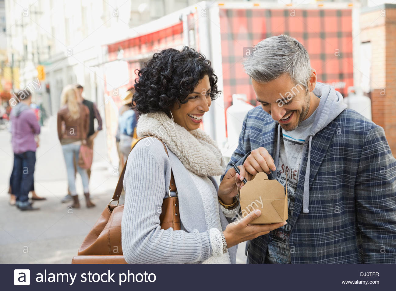 Glückliches Paar genießen Fast Food auf Stadtstraße Stockfoto