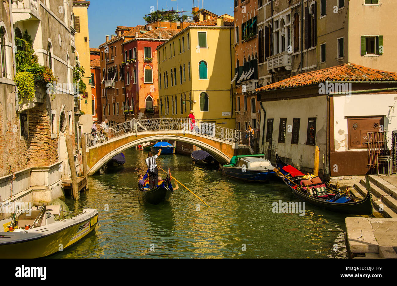 Gondoliere die Passagiere für eine informative Gondel fahren in Venedig, Italien. Stockfoto