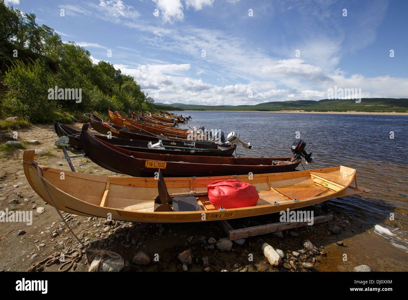 Holzboote mit Außenbordmotoren zum Lachsangeln am Fluss Teno, die natürliche Grenze zwischen Norwegen und Finnland in Lappland. Stockfoto