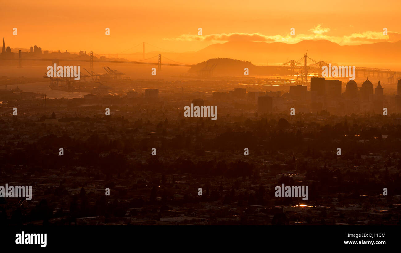 Blick vom Downtown Oakland, Kalifornien San Francisco Bay Bridge und der Golden Gate Bridge bei Sonnenuntergang Stockfoto