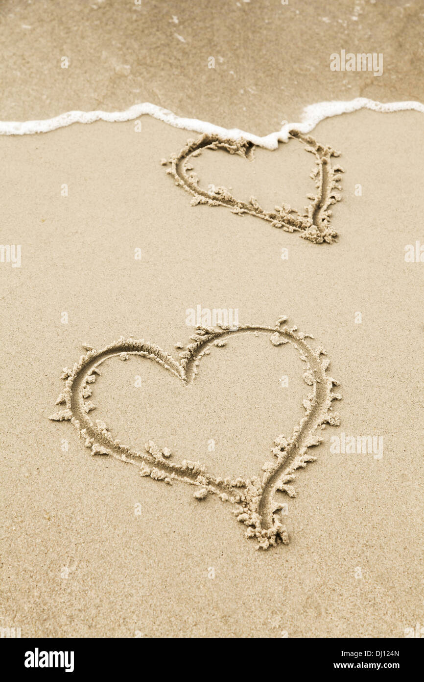 Herz zeichnen in den Sand des Strandes Stockfoto