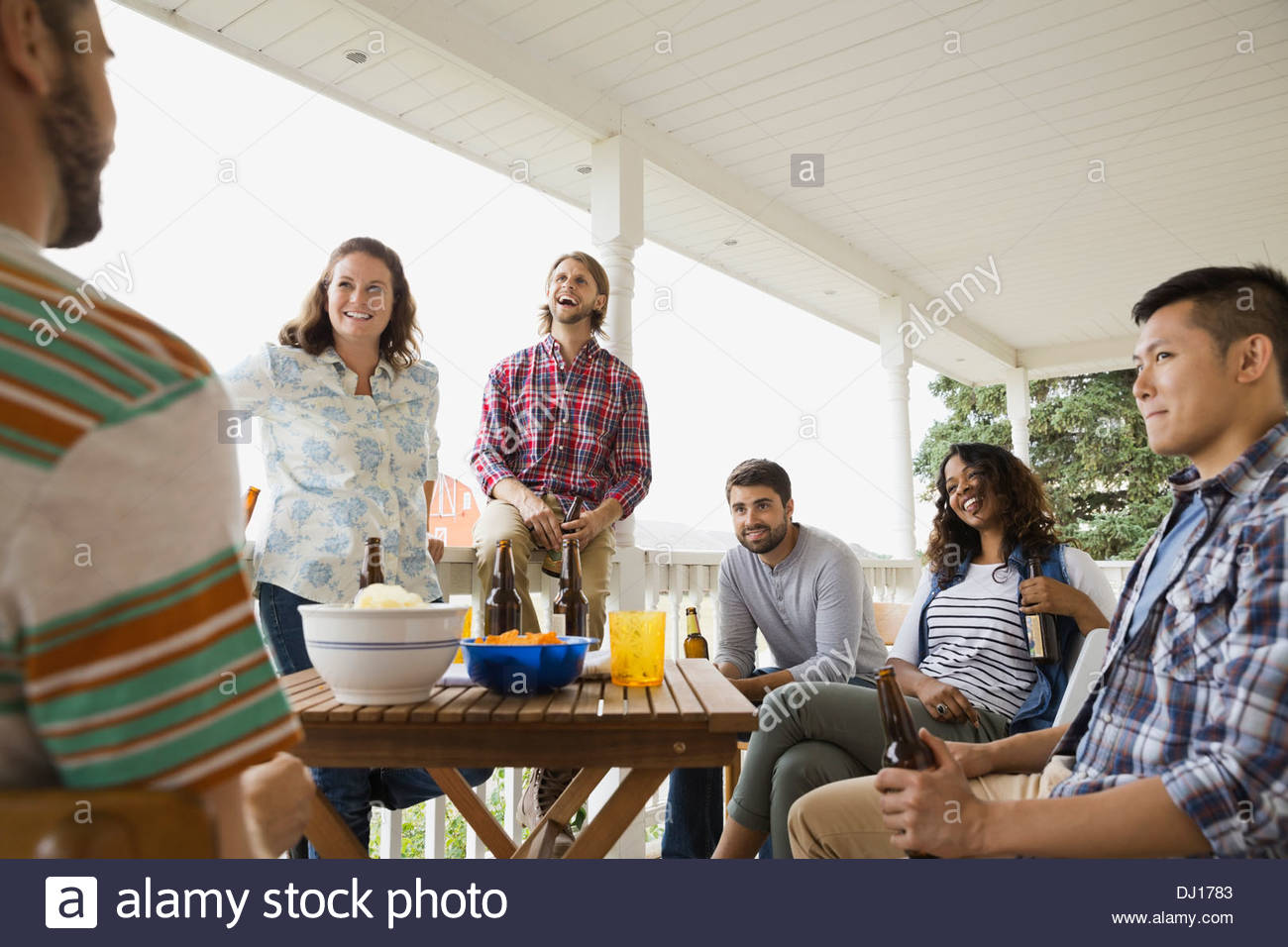Multiethnische Freunde genießen Getränke auf Veranda Stockfoto