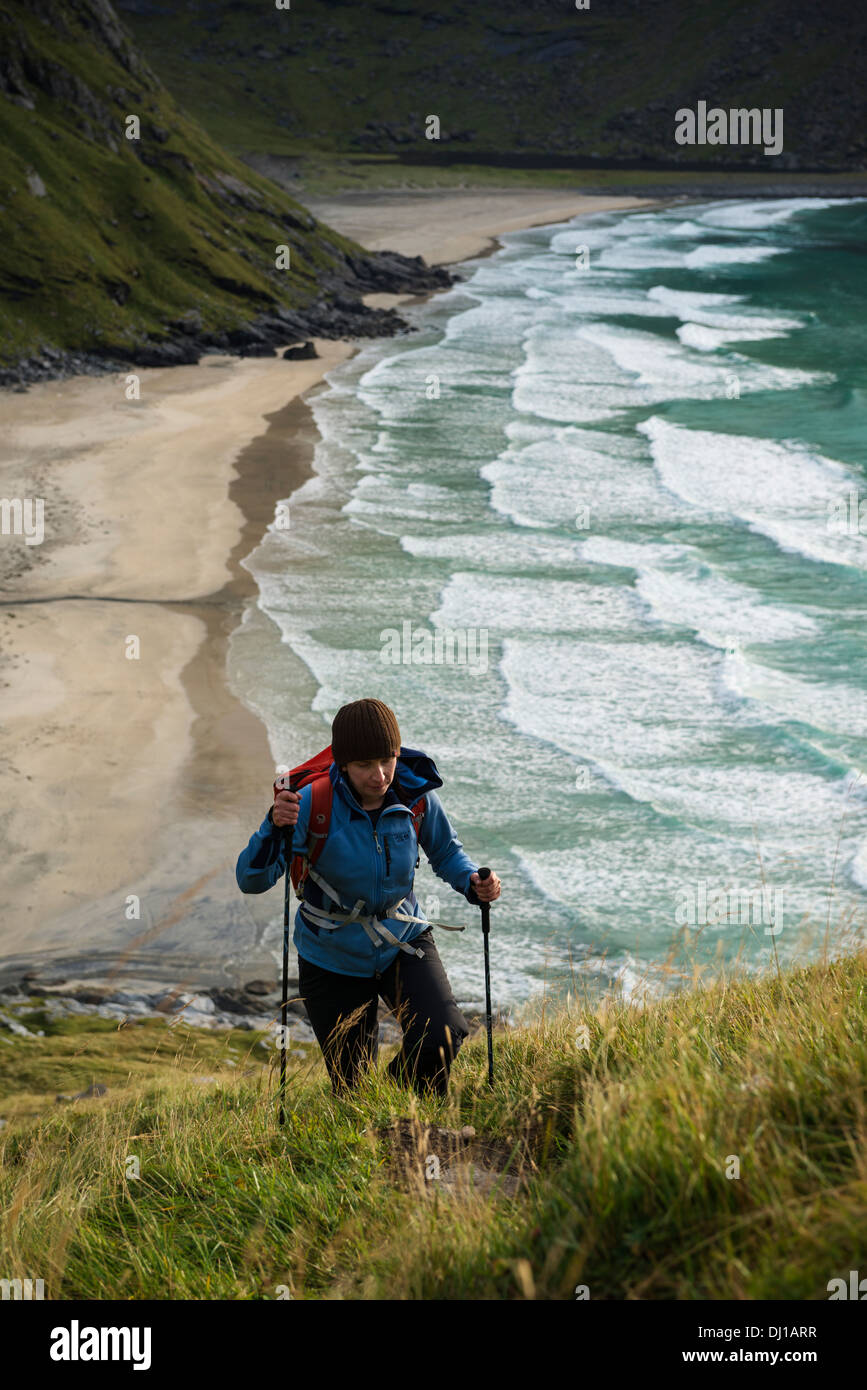 Weibliche Wanderer Wandern Wanderweg mit Kvalvika Strand im Hintergrund, Moskenesoy, Lofoten Inseln, Norwegen Stockfoto