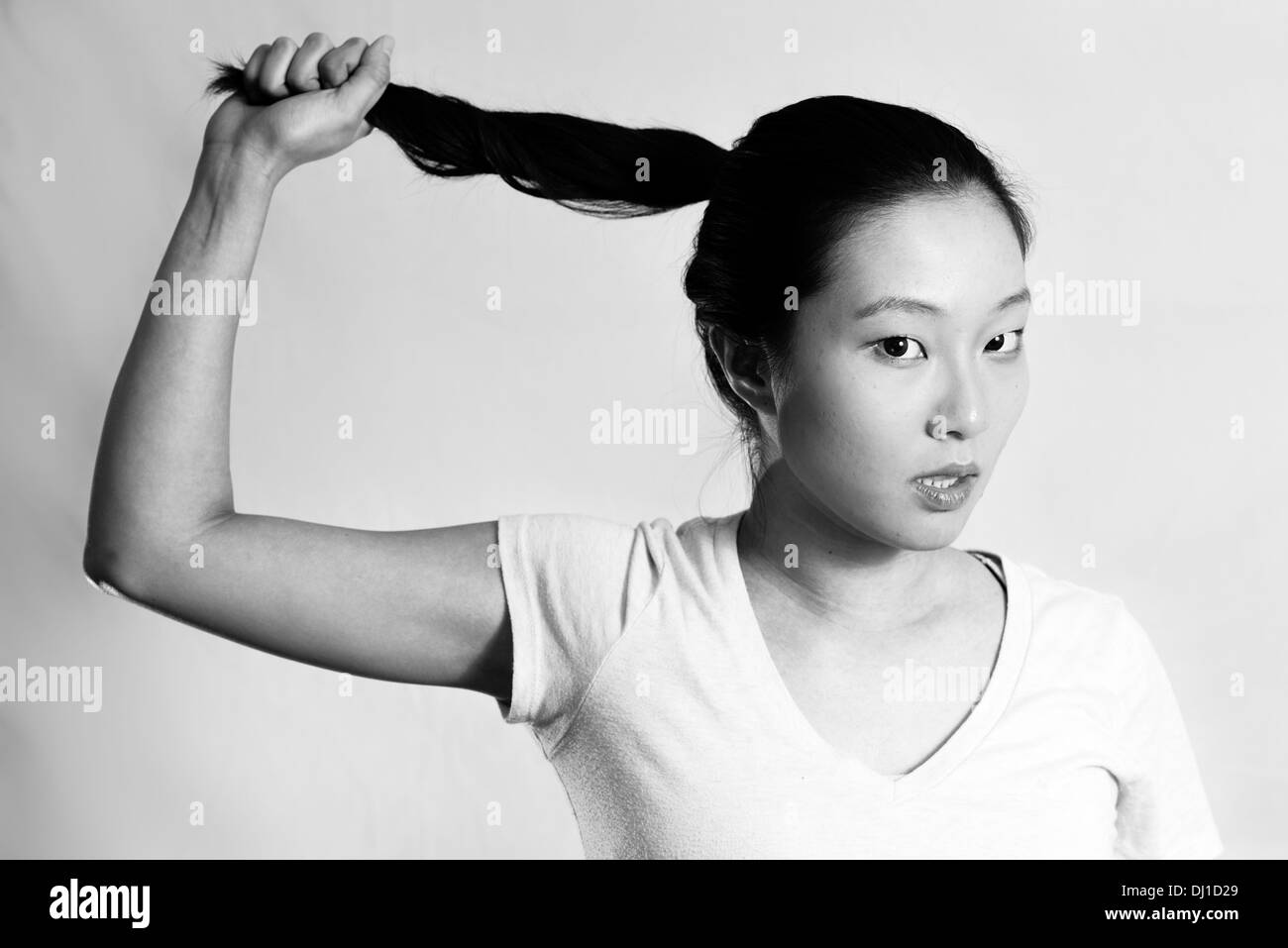 Porträt des einsamen jungen Frau ziehen ihr Haar sieht frustriert, schwarz / weiß Stil Stockfoto