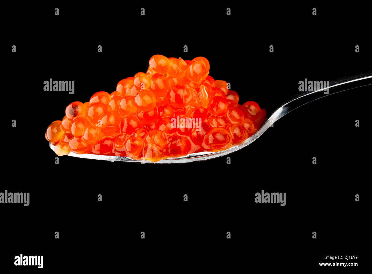 Roter Kaviar in Metall Teelöffel auf schwarzem Hintergrund isoliert Stockfoto