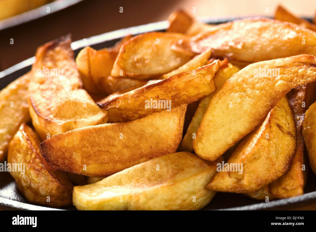 Frische hausgemachte knusprig gebratene Kartoffel wedges auf Metallplatte (selektiven Fokus, Fokus, ein Drittel in die Kartoffeln) Stockfoto
