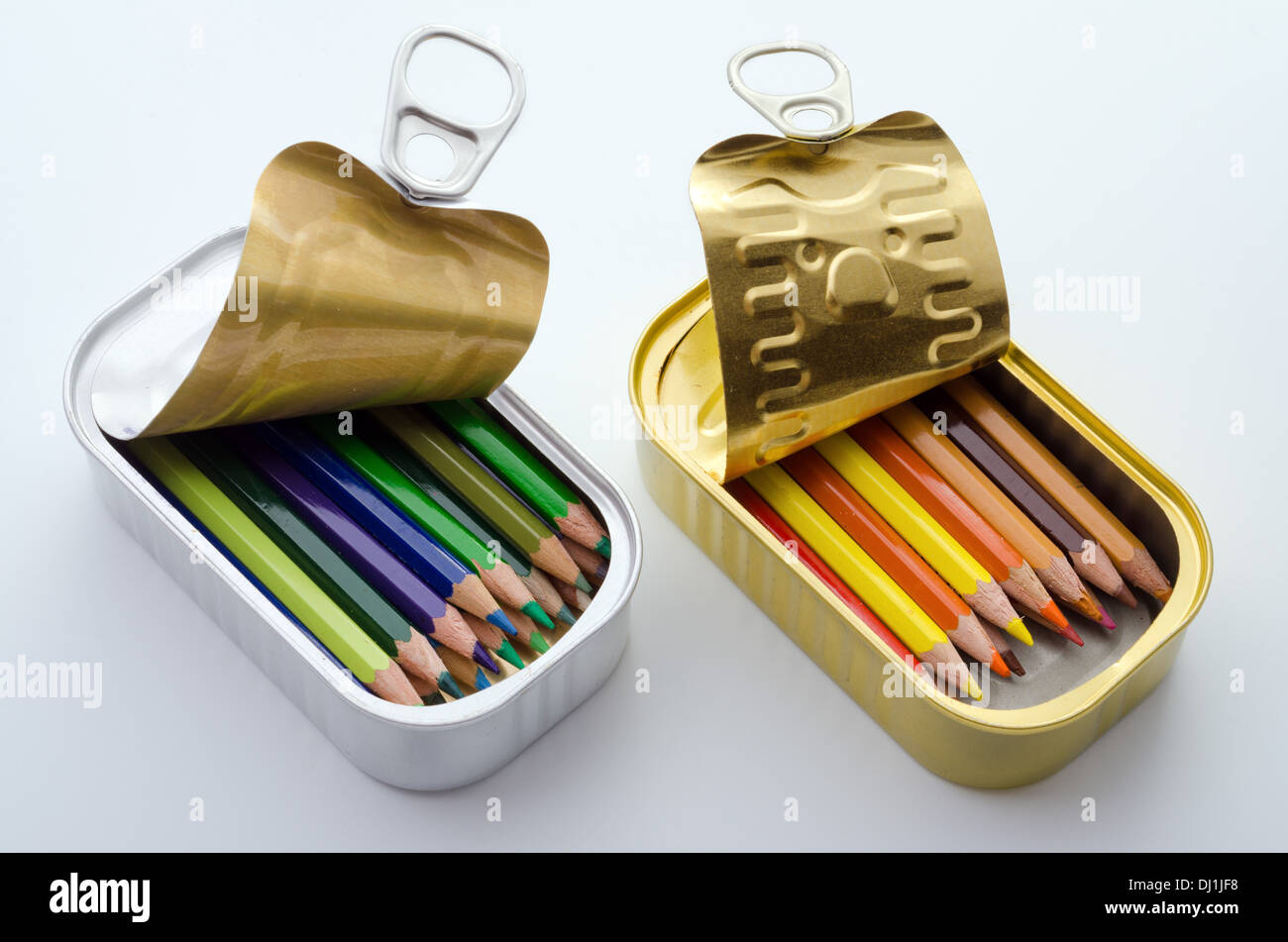 Anordnung von zwei Sardinen Dosen gefüllt mit ordentlich sortierte Farbstifte auf weißem Hintergrund. Stockfoto