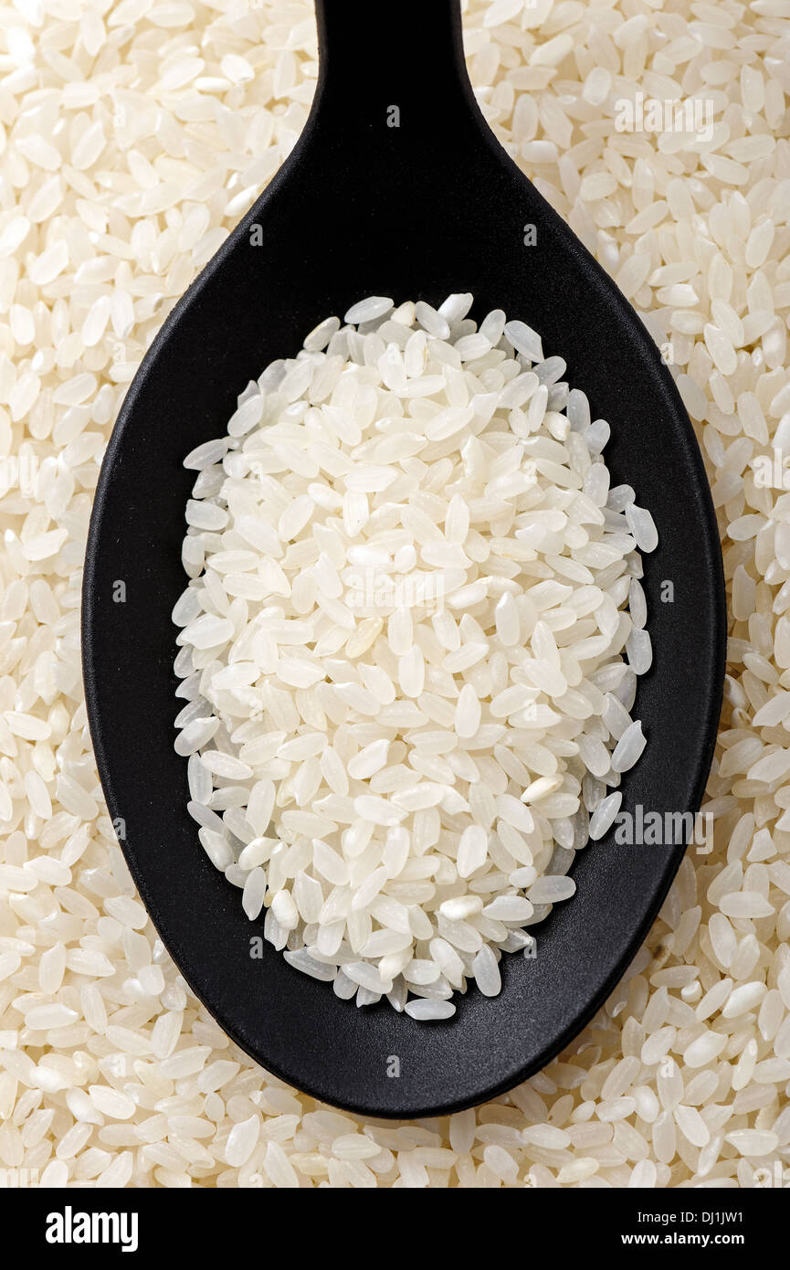 Draufsicht der schwarzen Löffel voll Calrose Reis Stockfoto