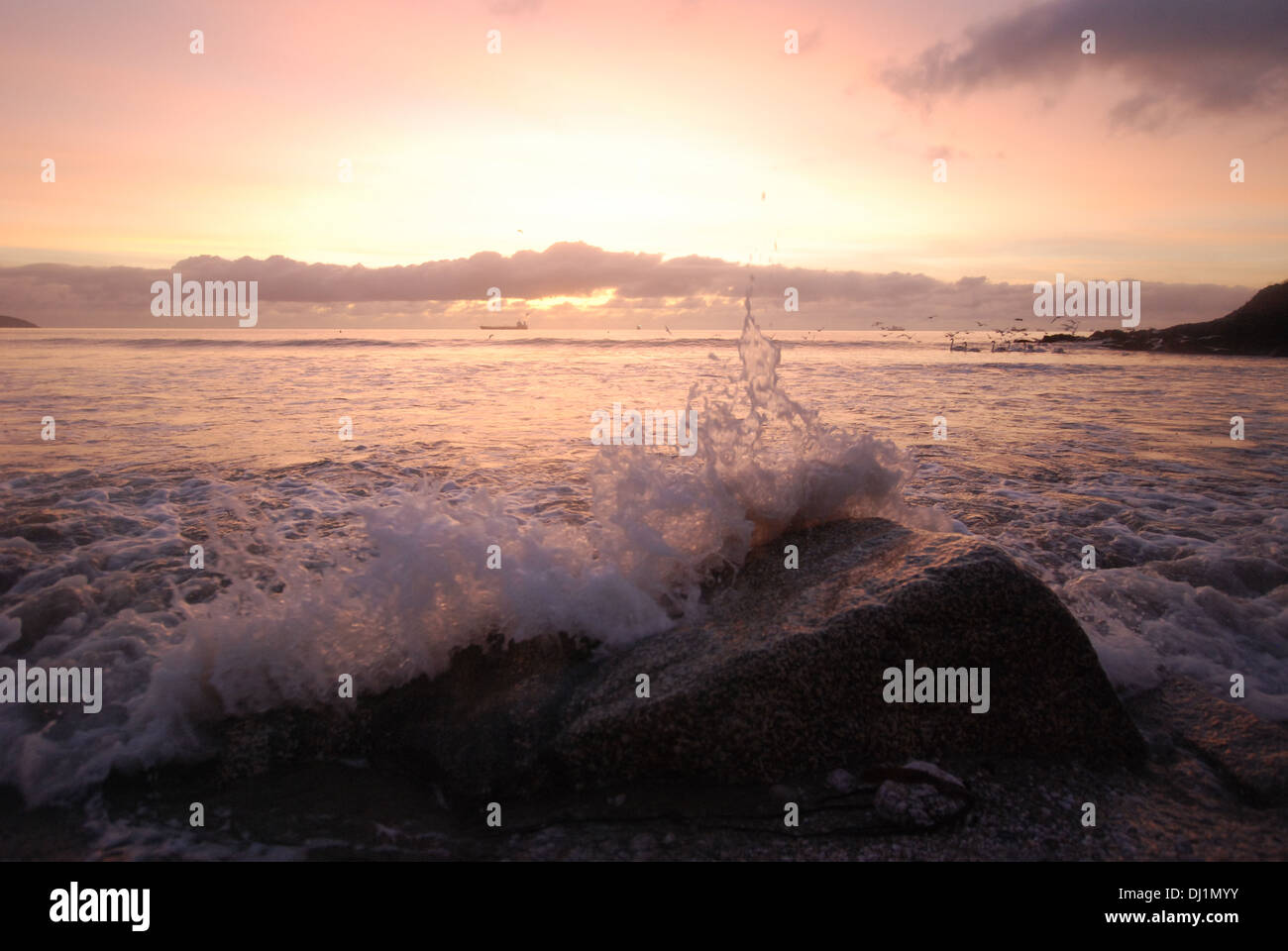 Ein Bild der Sonnenaufgang über dem Swanpool Strand; Wellen Sie brechen, Möwen im Hintergrund bearbeitet ausziehen. Stockfoto