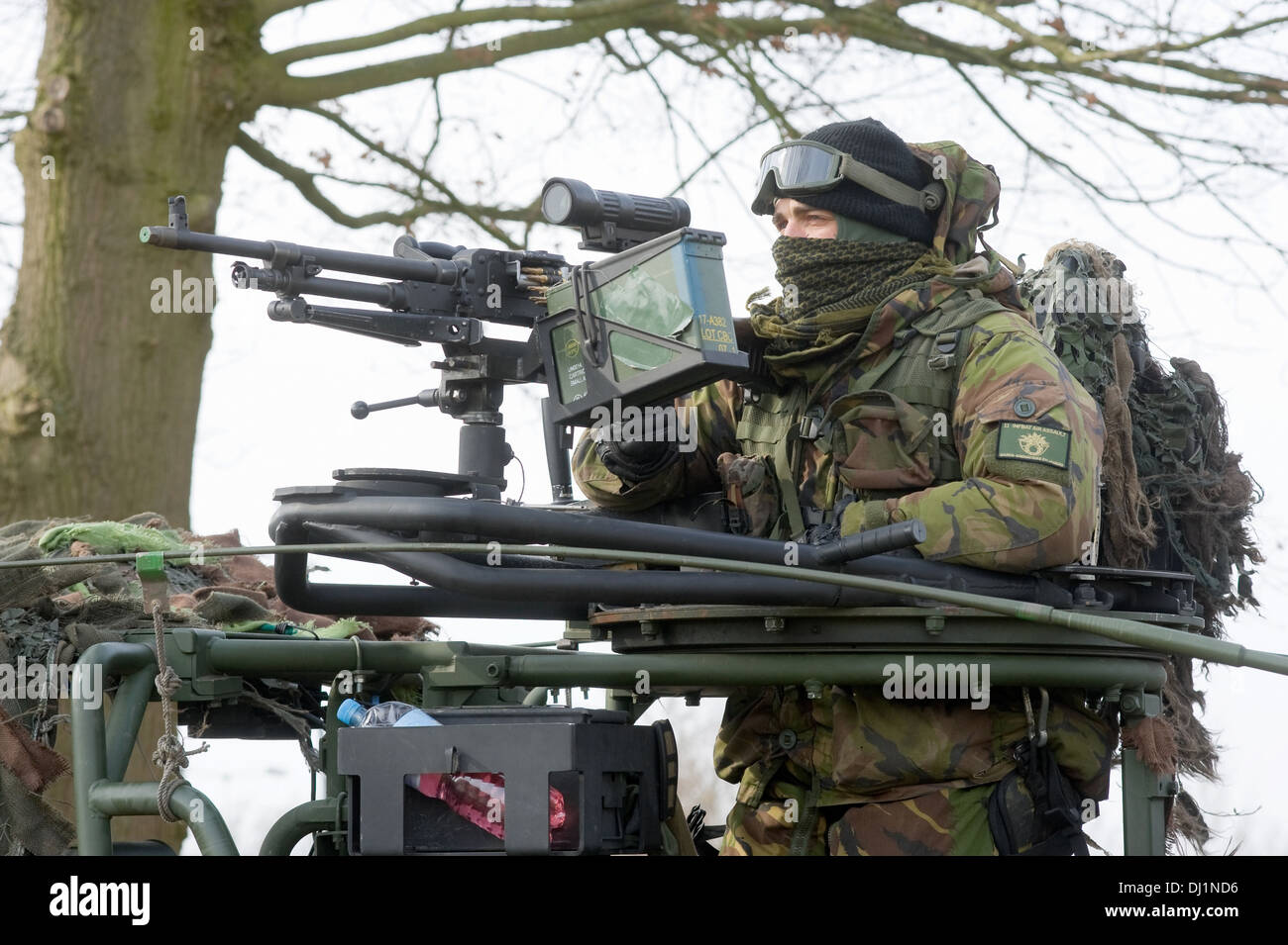 Ein Soldat der niederländischen Armee strebt seine automatische Waffe beim Training im winter Stockfoto