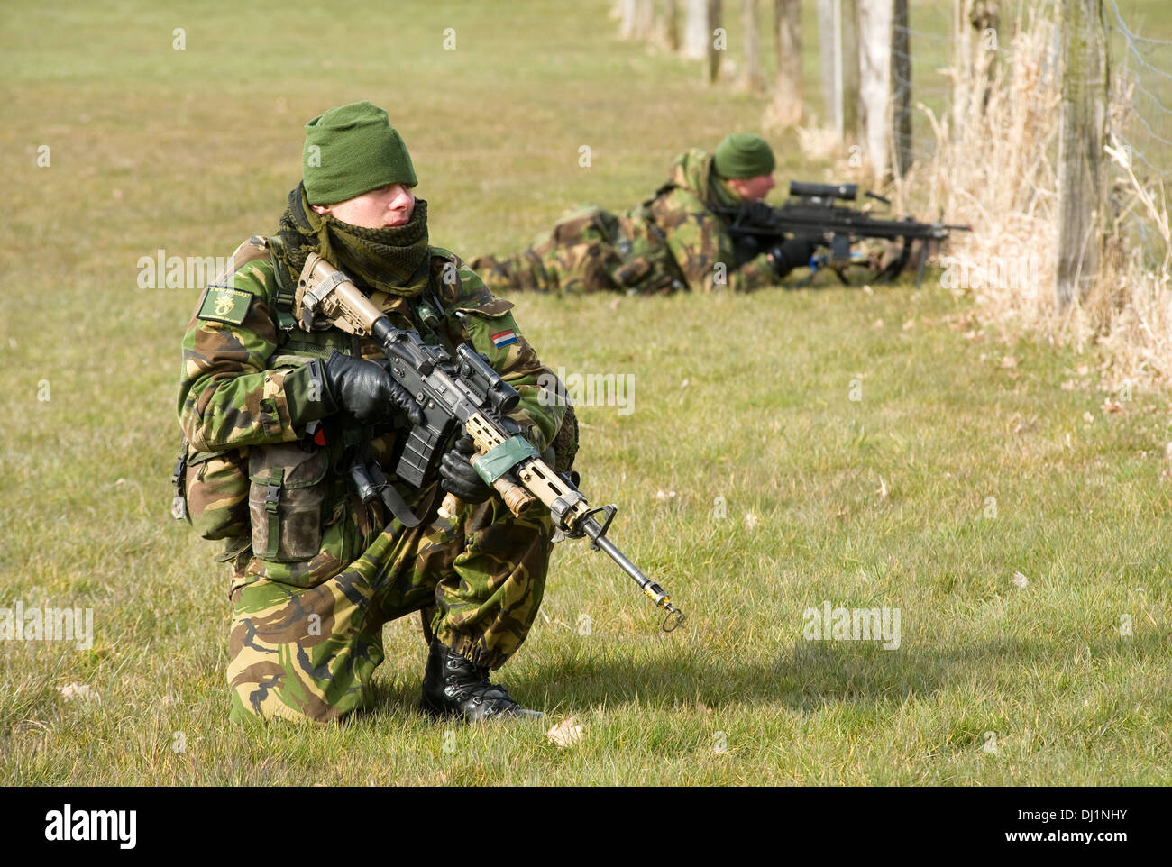 Zwei Soldaten mit ihren automatischen Waffen während eines Trainings der Special Forces an einem kalten Tag im freien Feld getarnt Stockfoto