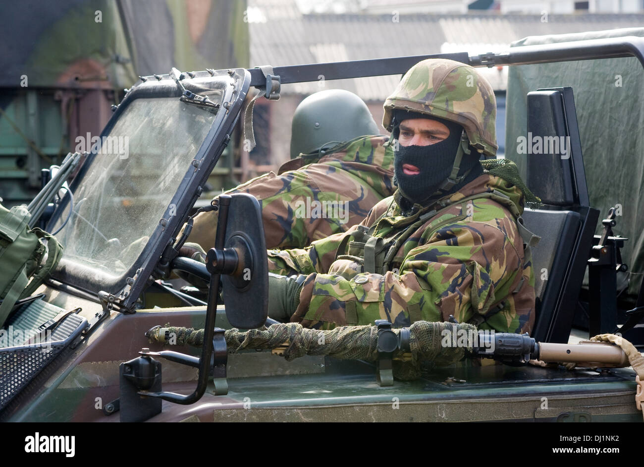 Zwei getarnte Soldaten sind einen Jeep während eines Trainings der Special Forces an einem kalten Tag parken. Stockfoto
