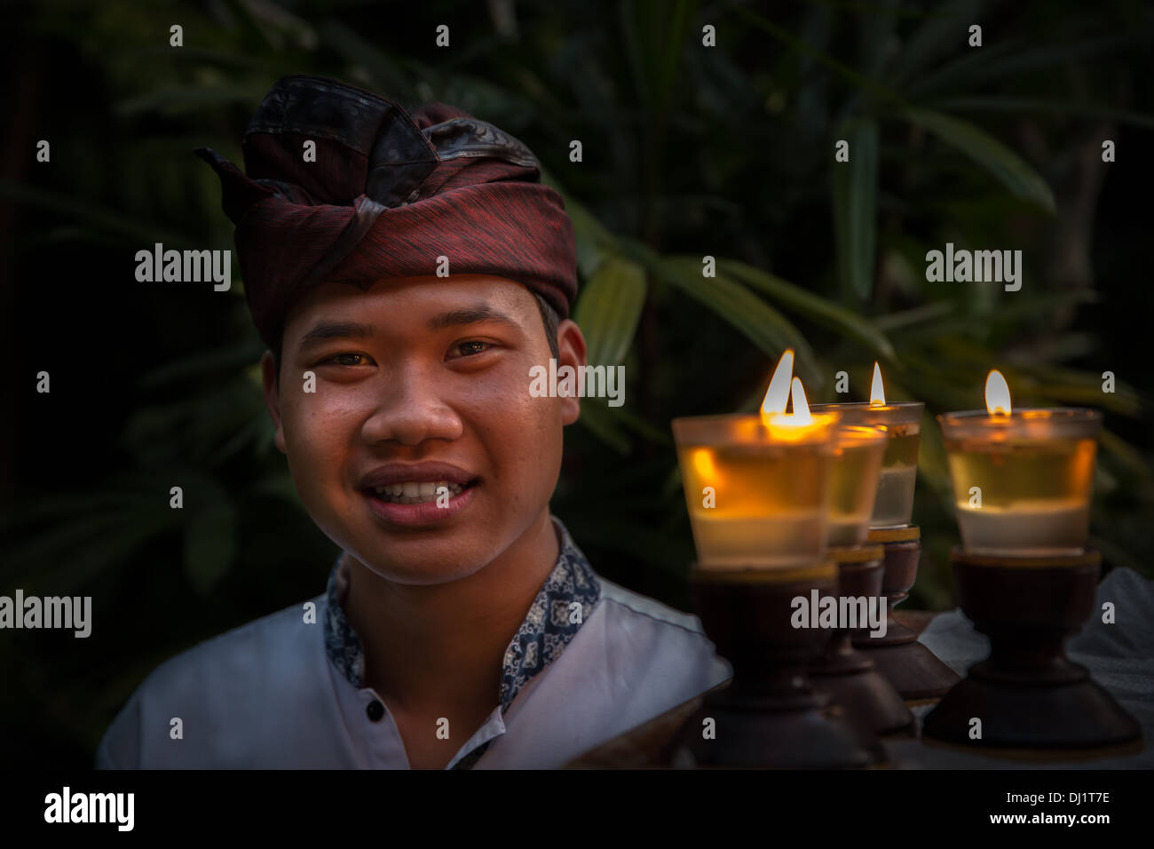 Einen balinesischen Mann in traditioneller Kleidung Kerzen tragen, Ubud, Bali, Indonesien Stockfoto