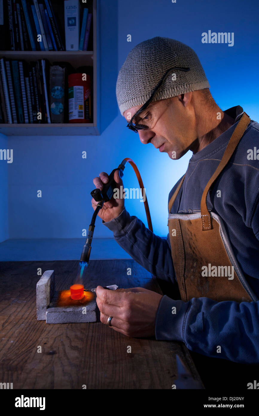 Mann mit einer Lötlampe auf eine Workshop-Bank. Stockfoto