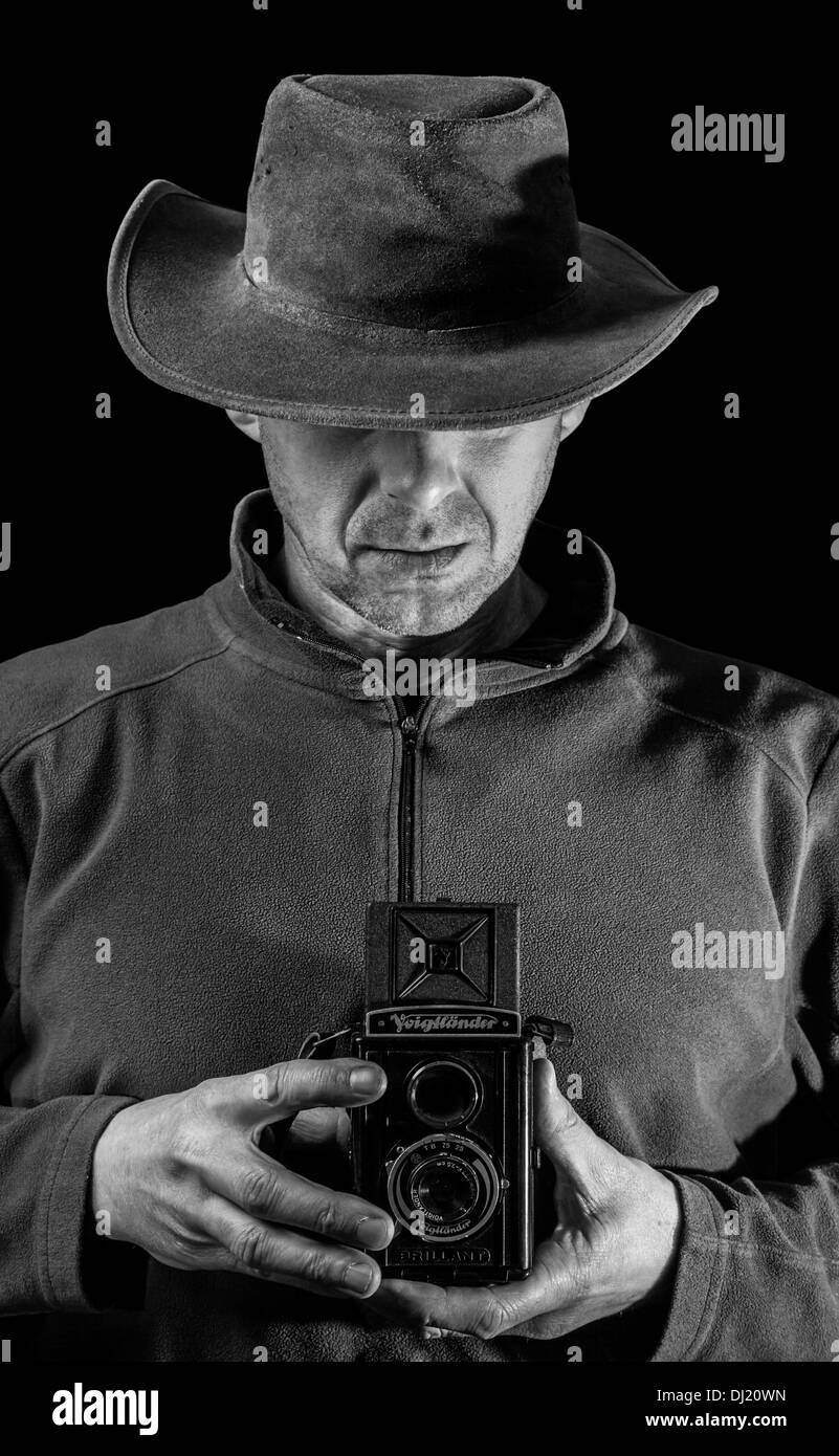 Ein Mann hält eine Vintage-Kamera. Stockfoto