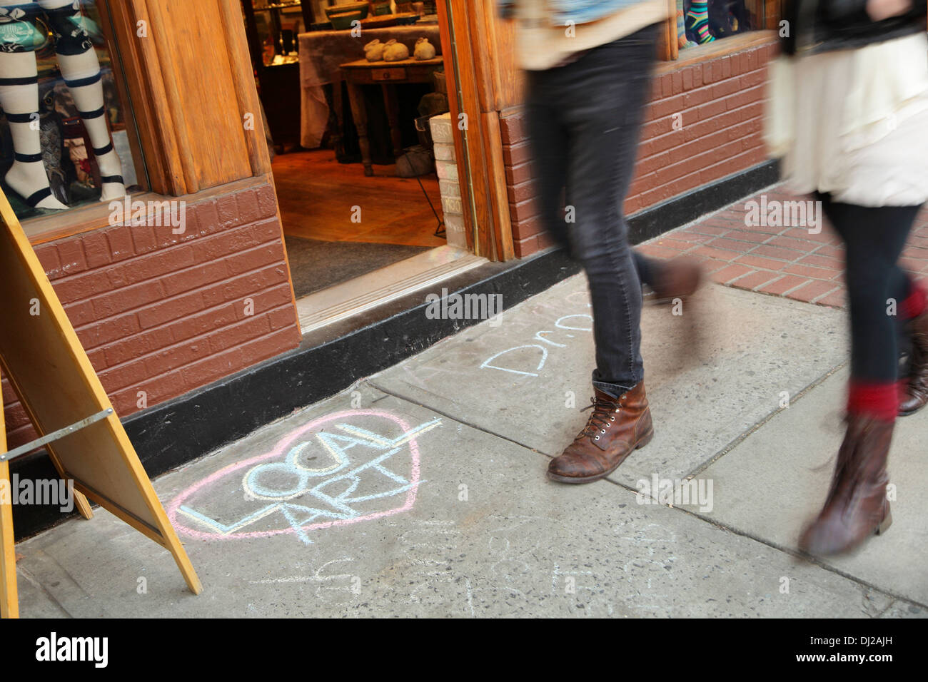 Fußgänger auf Biltmore Avenue gehen vorbei an eine Kreidezeichnung Förderung lokalen Kunst, Asheville, North Carolina, USA Stockfoto