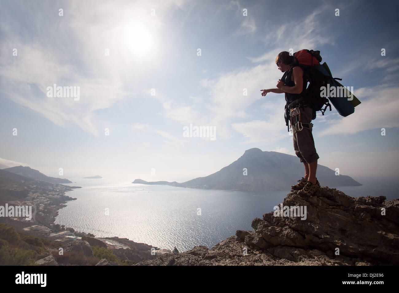 Junger Mann stehend auf einem Felsen gegen malerischen Blick auf Meer Stockfoto