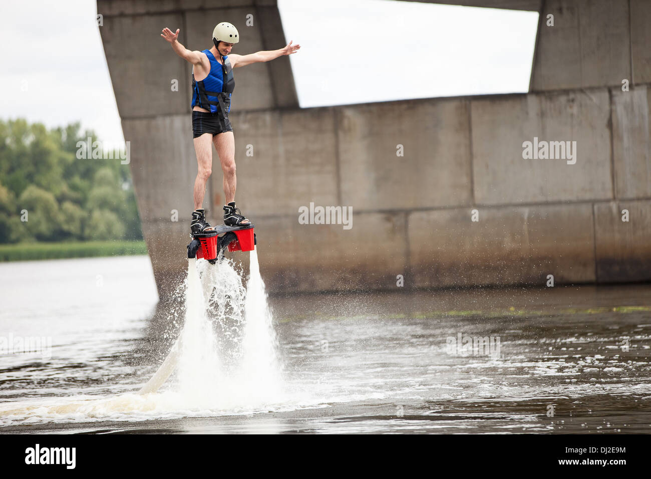 Junger Mann mit Flyboard Maschine am Fluss Stockfoto