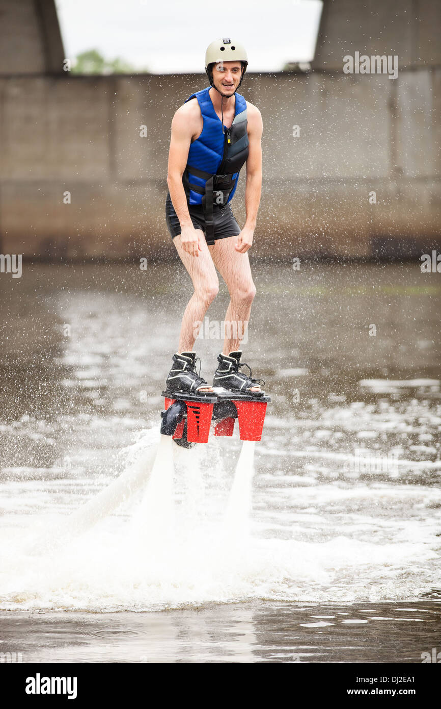 Junger Mann mit Flyboard Maschine am Fluss Stockfoto