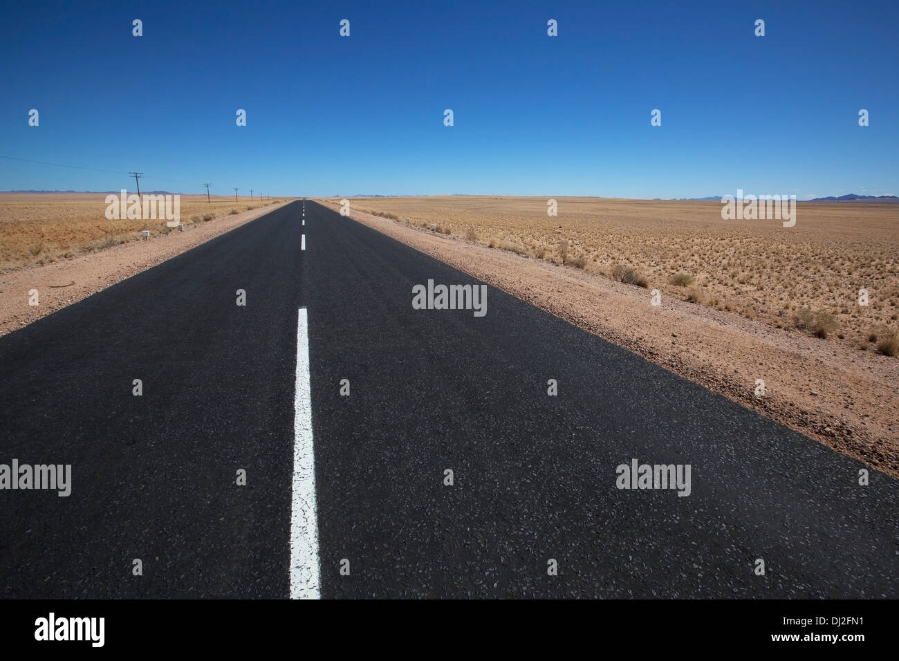 Weiße Linie auf einer asphaltierten Straße In der Wüste; Garub, Namibia Stockfoto