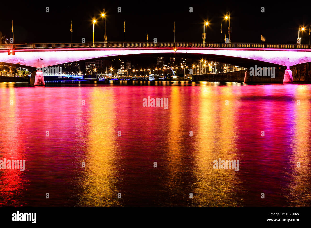 Nacht-Blick auf die "Pont des Arches" (Brücke) in der Stadt Lüttich in Belgien. Maas mit Reflexionen von Licht und Farbe. Stockfoto