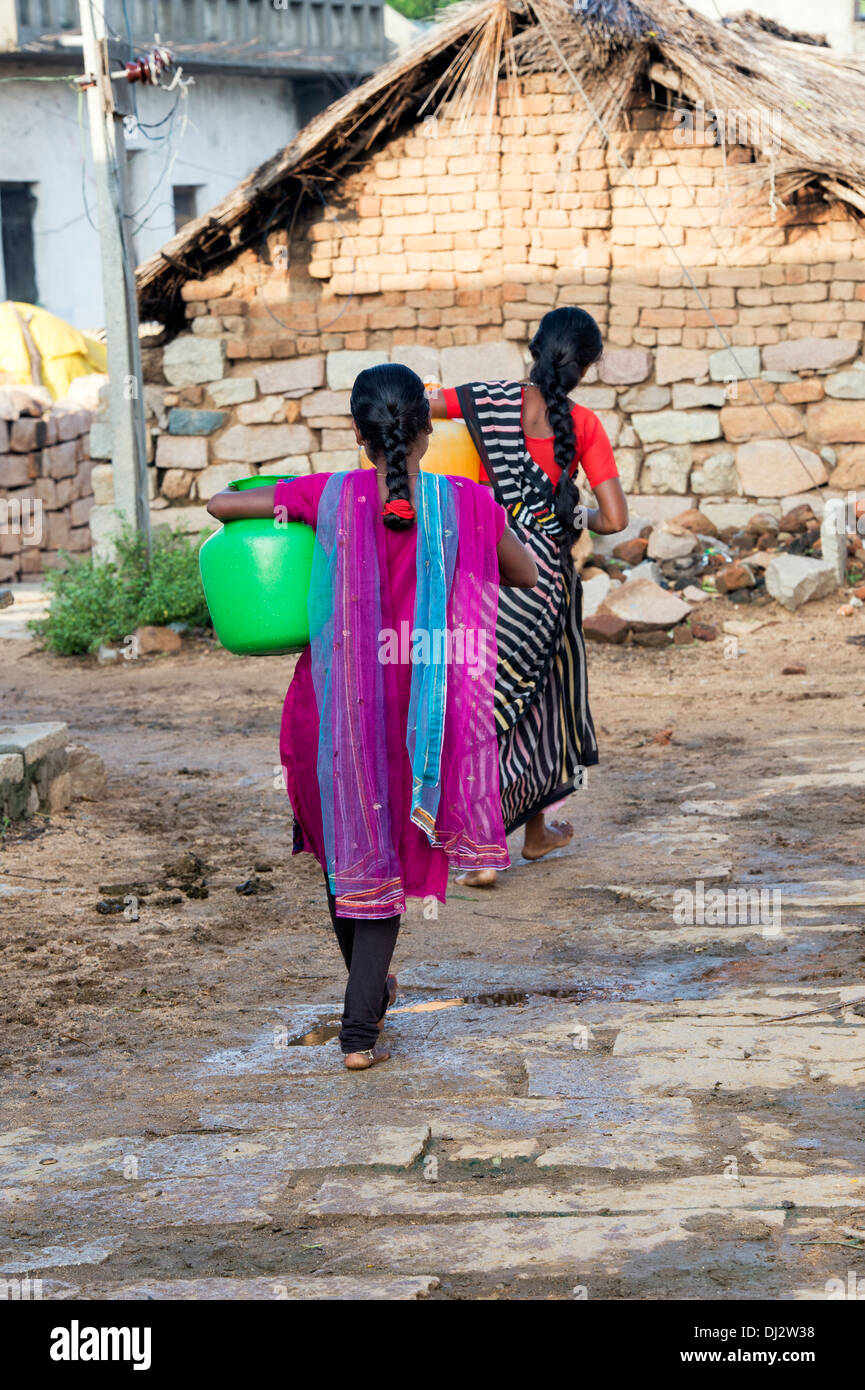 Indische Teenager-Mädchen mit einem Wassertopf in einem indischen Dorf Straße. Andhra Pradesh, Indien Stockfoto