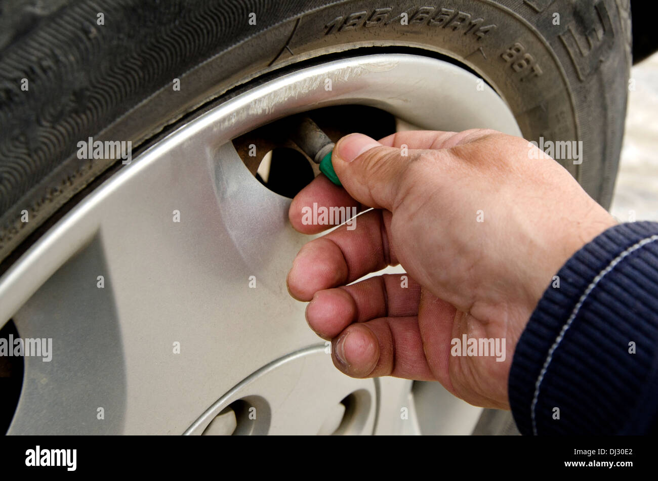 Nahaufnahme von Personen Hand, Ausbau der Gap ein Autoreifen für den Druck zu prüfen. Stockfoto