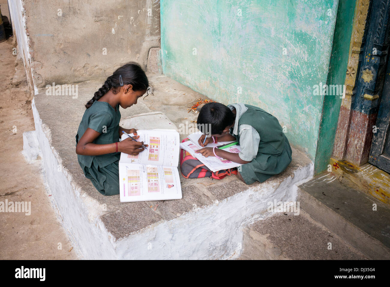 Junge indische Mädchen tun Schule arbeiten außerhalb ihrer indischen Dorf nach Hause. Andhra Pradesh, Indien Stockfoto