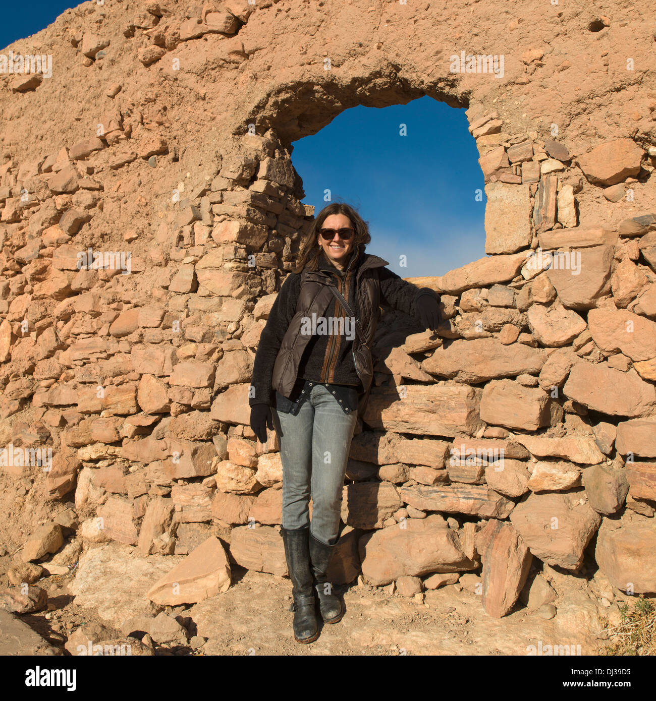 Eine Frau, die durch eine Felswand mit einem Fenster posiert; AIT Benhaddou Sous-Massa-Draa Marokko Stockfoto