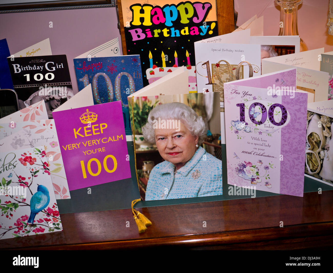 Auswahl an 100 Jahre alten Geburtstagskarten auf dem Sideboard mit der traditionellen Kultkarte von HRH Queen Elizabeth II in der Mitte Stockfoto