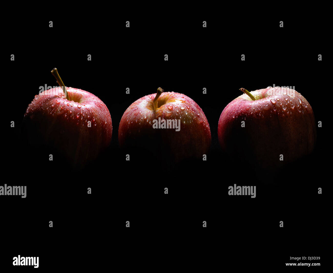 drei Äpfel in Wassertröpfchen bedeckt Stockfoto