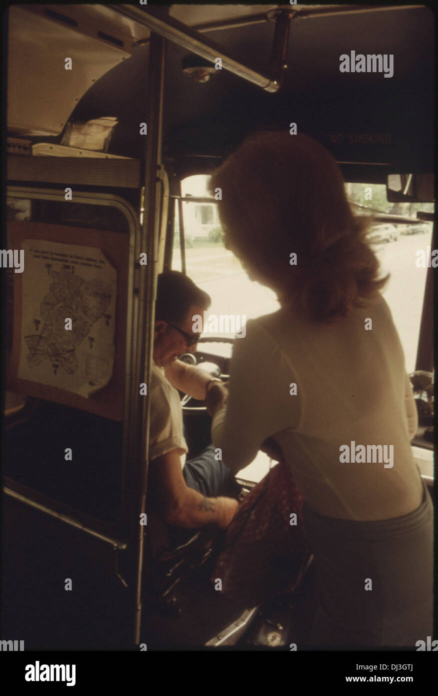 Dieses Bild zeigt einen Passagier, der seinen Fahrpreis zahlt, nachdem er in einen „Dial-A-Ride“-Bus mit Funkverbindung eingestiegen ist. Dieser Service bietet bequemen, persönlichen Transport für Einzelpersonen von zu Hause zu verschiedenen Zielen. Stockfoto